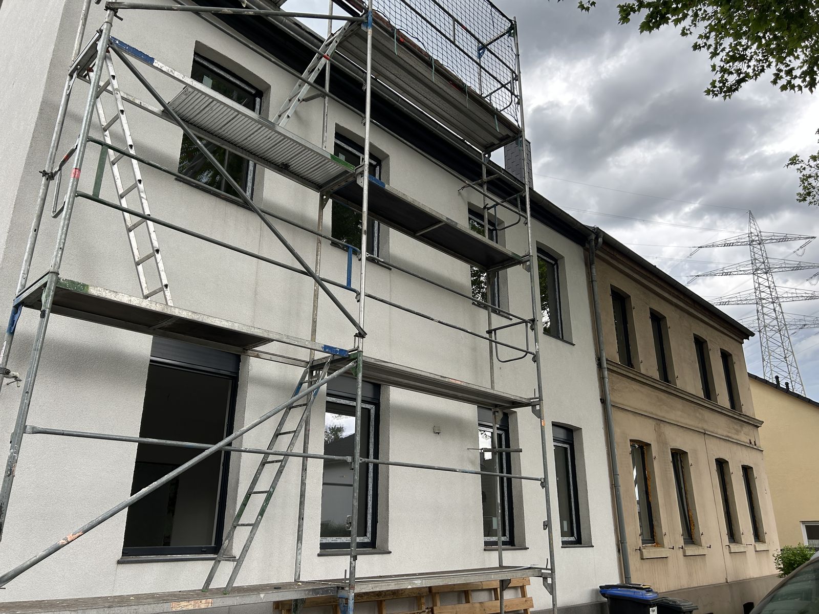 Fassade mit neu eingebauten Fenstern während der Montagearbeiten
